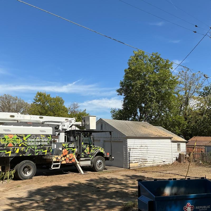 Bucket truck near white garage for tree removal