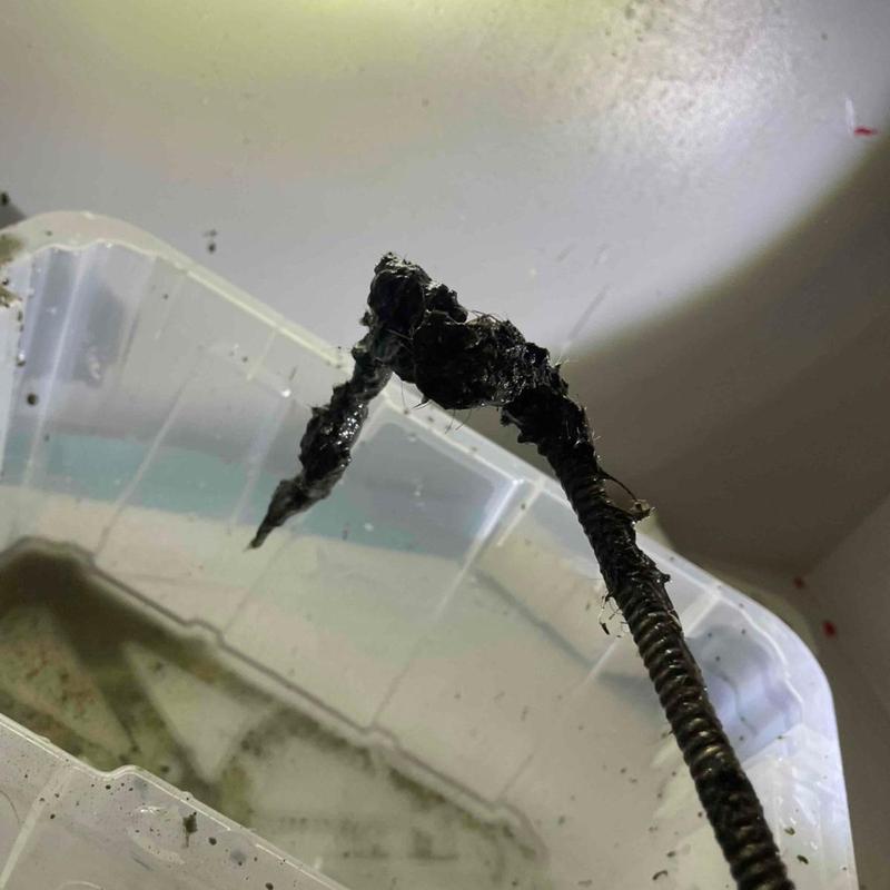 Bathroom sink drain cable with debris blockage removed