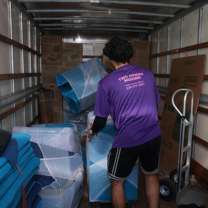 Furniture wrapped in protective moving blankets inside truck