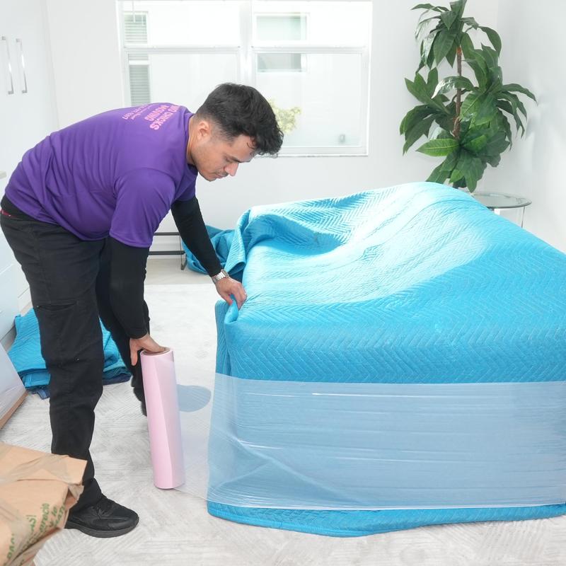 Furniture wrapped with moving blanket and plastic wrap