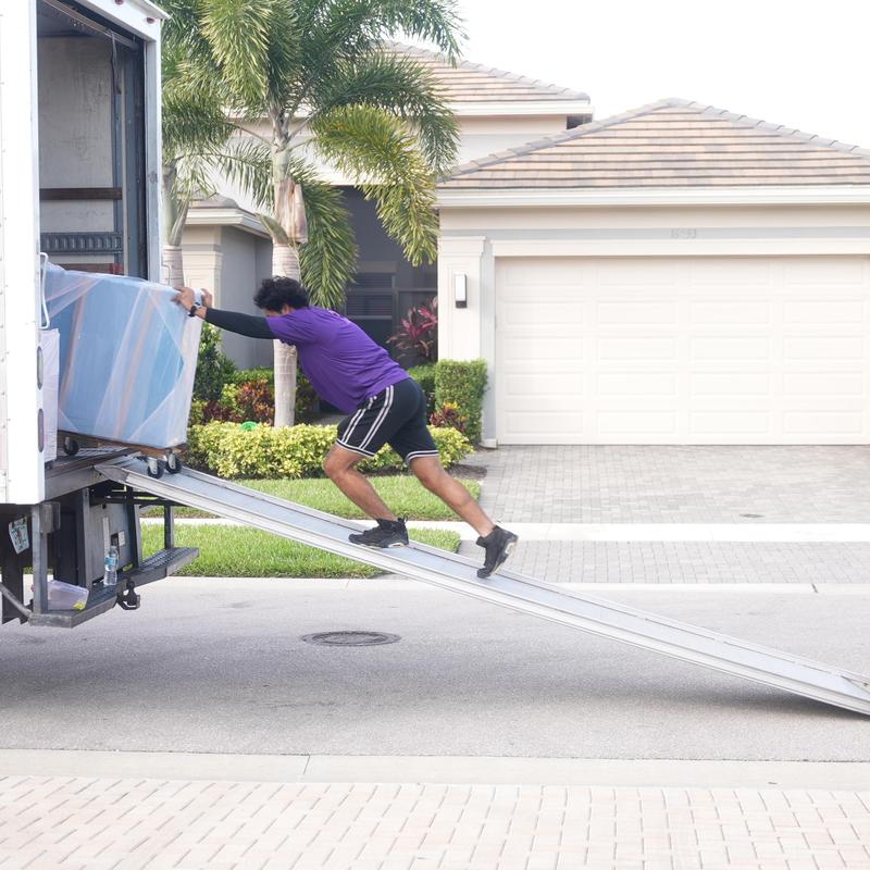 Furniture dolly loading onto moving truck ramp