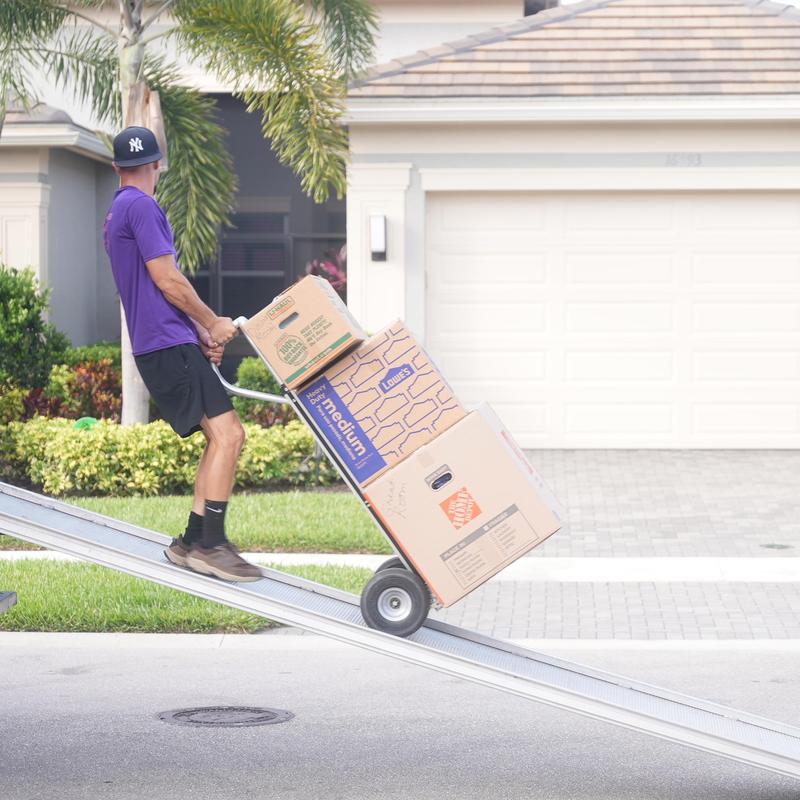 Moving dolly with packed moving boxes on ramp