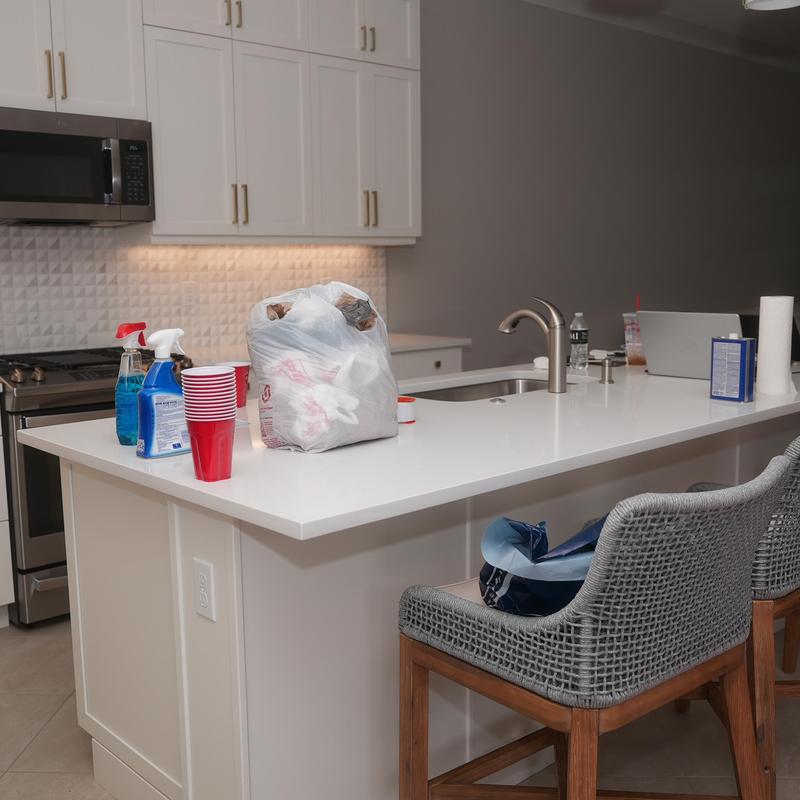 Kitchen island with cleaning supplies and trash bag