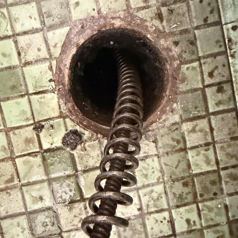Main line drain cleaning auger in tiled floor drain Main line drain cleaning auger in tiled floor drain