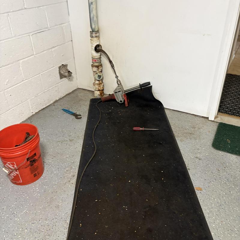 Drain pipe with snake tool and plumbing tools on floor Drain pipe with snake tool and plumbing tools on floor