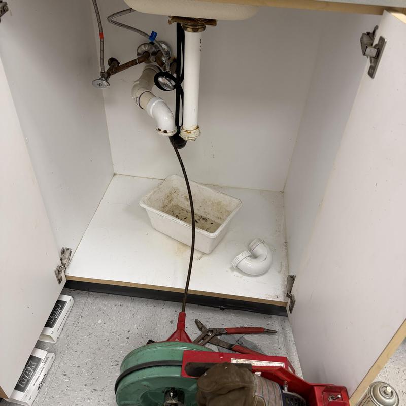 Main line drain with auger tool inside cabinet Main line drain with auger tool inside cabinet