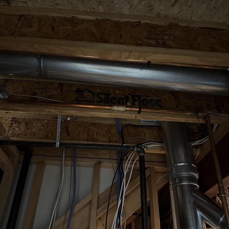 Metal HVAC ductwork and wiring in unfinished ceiling