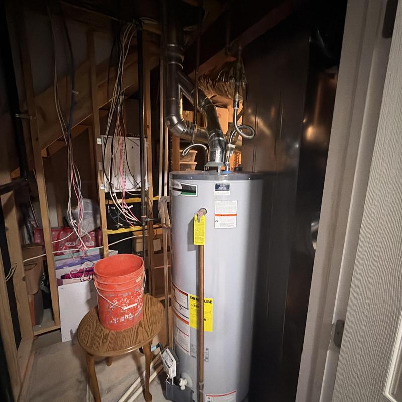 Water heater with vent pipes and wiring in basement