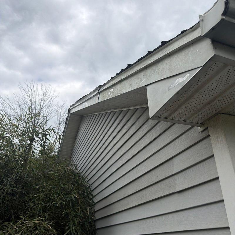 Metal fascia and gutter with hail damage and paint wear