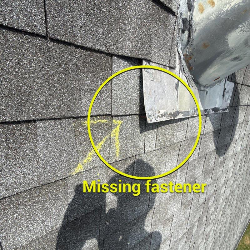 Roof shingles near chimney with missing fastener