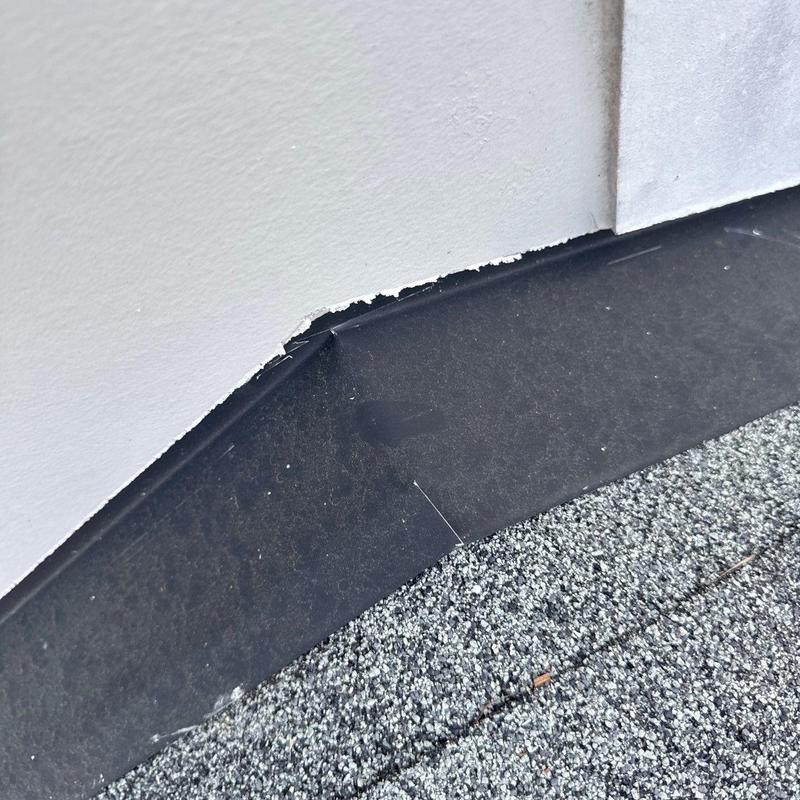 Roof flashing with sealant damage near wall base
