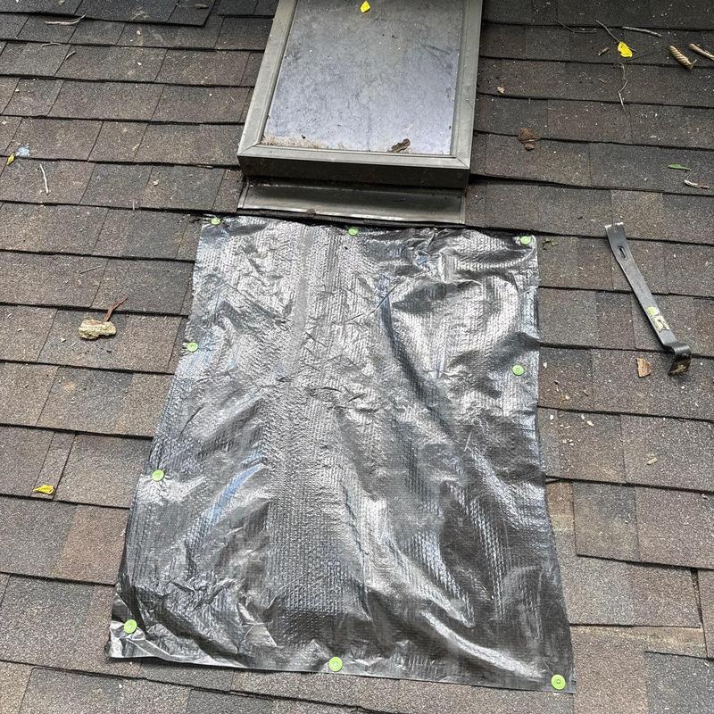 Roof shingles with temporary tarp covering damage