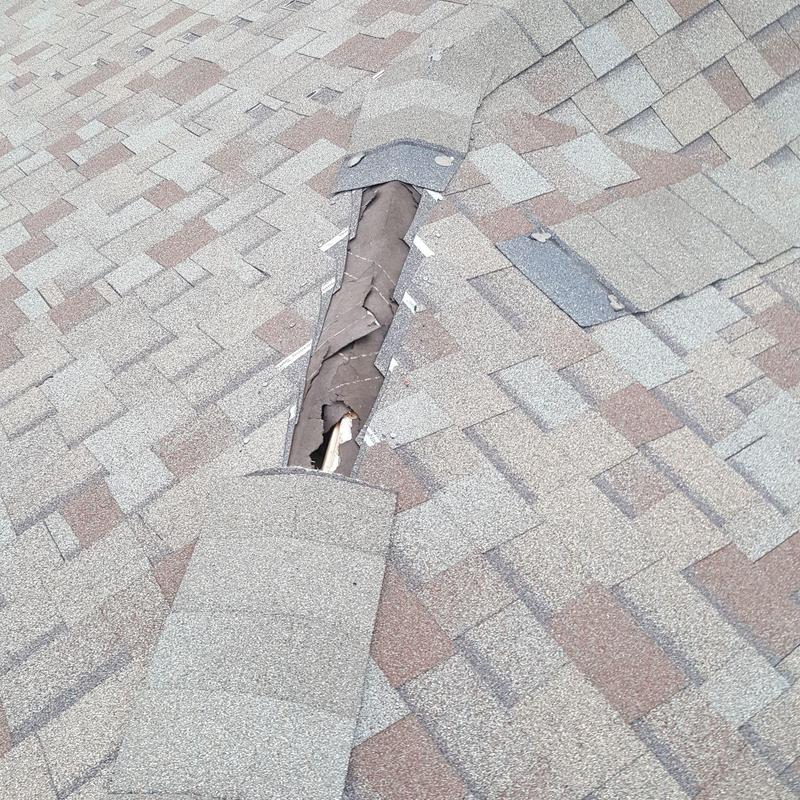 Asphalt roof shingles lift showing damaged underlayment Asphalt roof shingles lift showing damaged underlayment