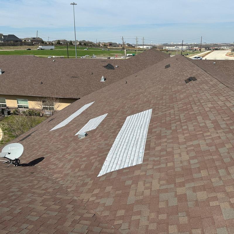 Asphalt shingle roof with metal patch repairs Asphalt shingle roof with metal patch repairs