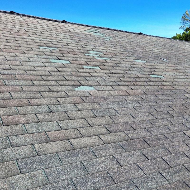 Three tab shingle roof with storm damage and wear Three tab shingle roof with storm damage and wear