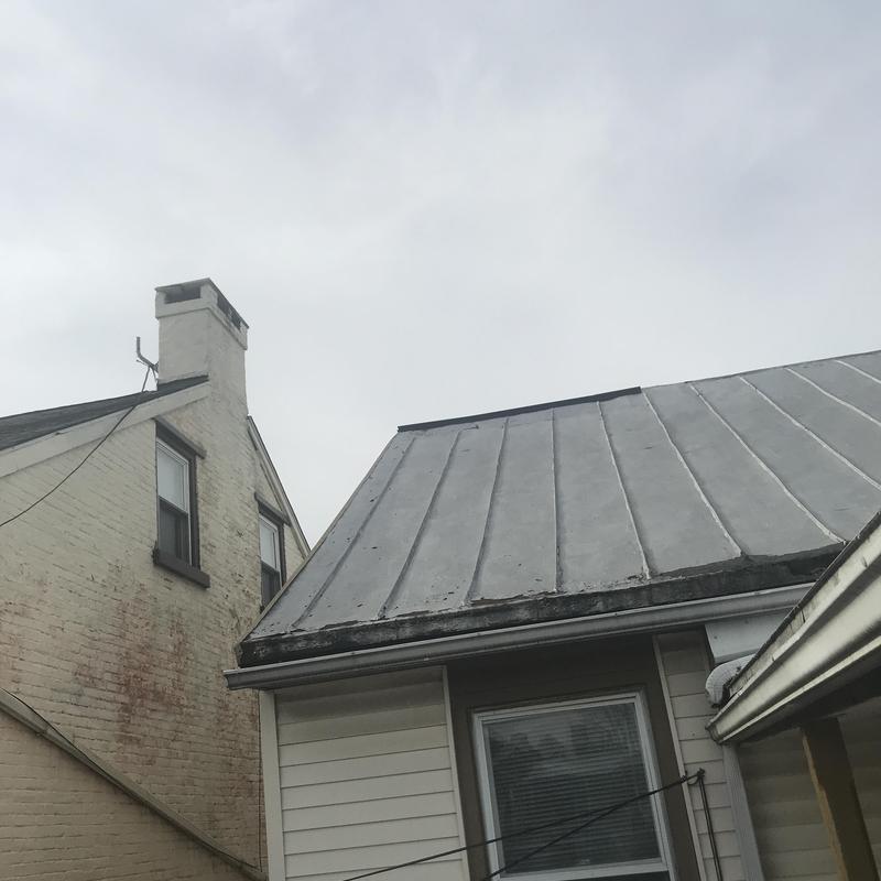Standing seam metal roof with visible wear and dirt Standing seam metal roof with visible wear and dirt