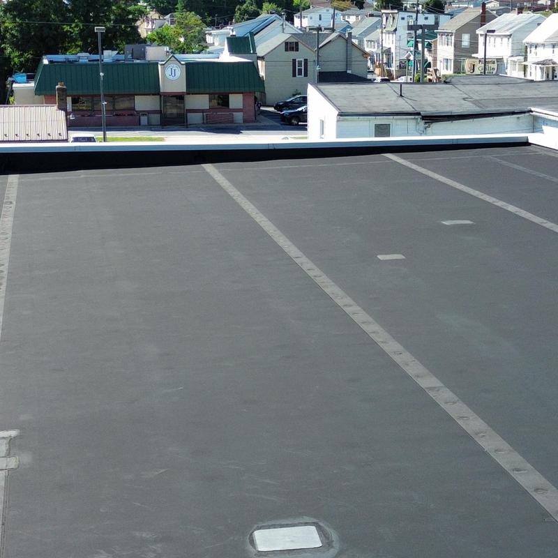 EPDM flat roof with patched punctures on commercial building EPDM flat roof with patched punctures on commercial building