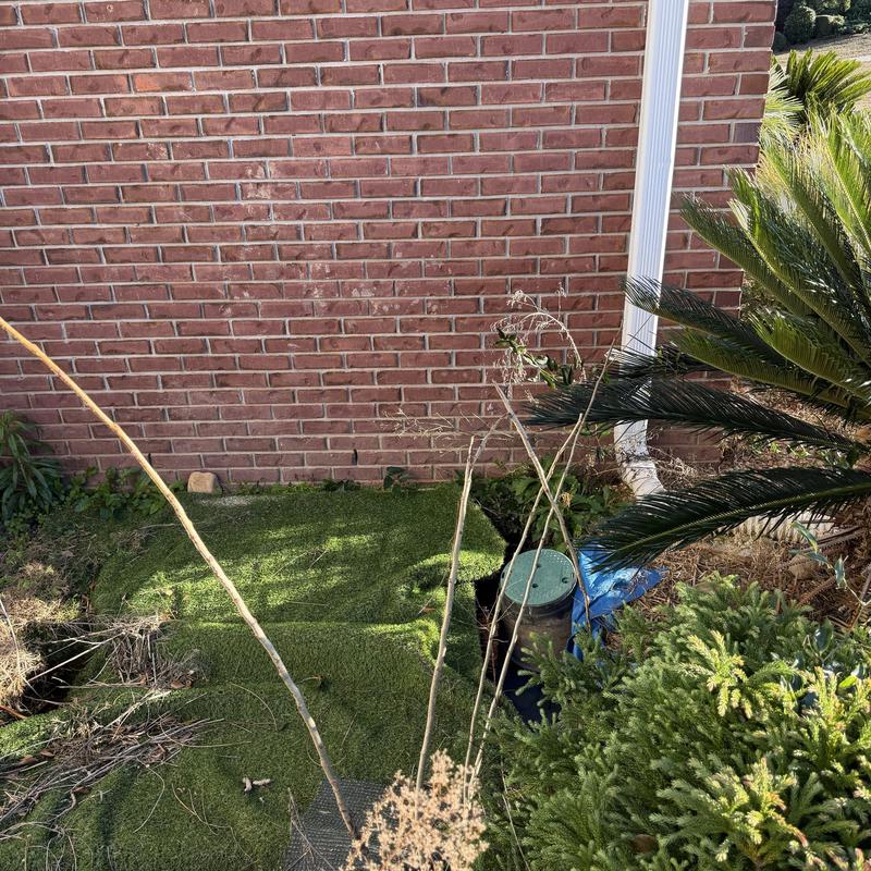 Outdoor sprinkler valve box near brick wall and plants Outdoor sprinkler valve box near brick wall and plants