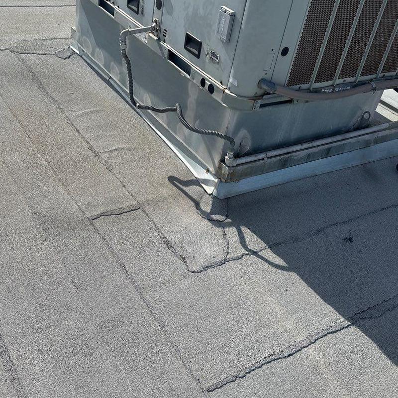 Rooftop HVAC unit flashing with cracked roofing membrane Rooftop HVAC unit flashing with cracked roofing membrane