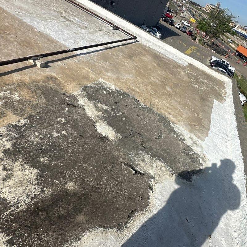 Flat commercial roof surface with patching and wear signs Flat commercial roof surface with patching and wear signs