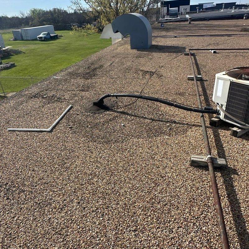 Built-up gravel roof surface with vent and HVAC unit Built-up gravel roof surface with vent and HVAC unit