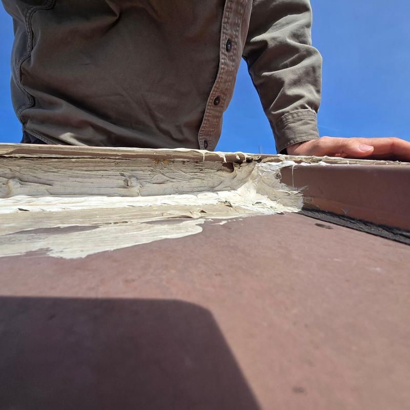 Roof flashing with deteriorated sealant under inspection Roof flashing with deteriorated sealant under inspection