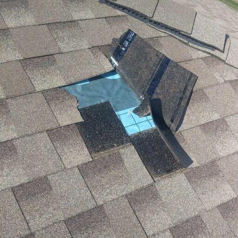 Roof shingles lifted revealing underlayment and roof deck Roof shingles lifted revealing underlayment and roof deck