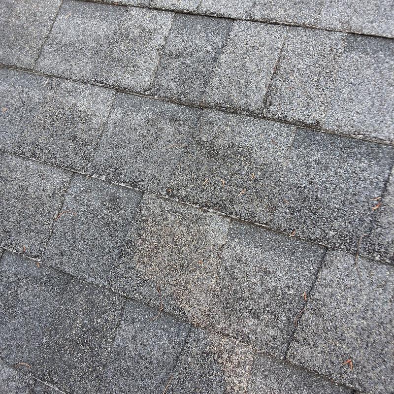 Asphalt shingle roof close-up showing wear and granules