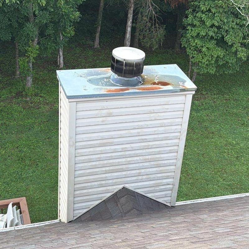 Metal chimney cap with rust stains on roof