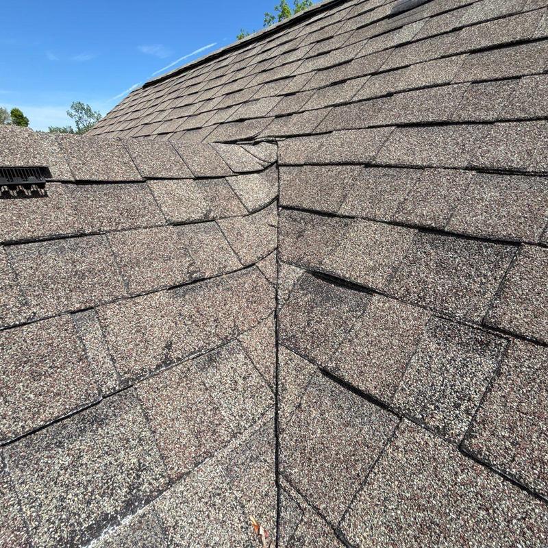 Asphalt roof shingles with hail damage near valley