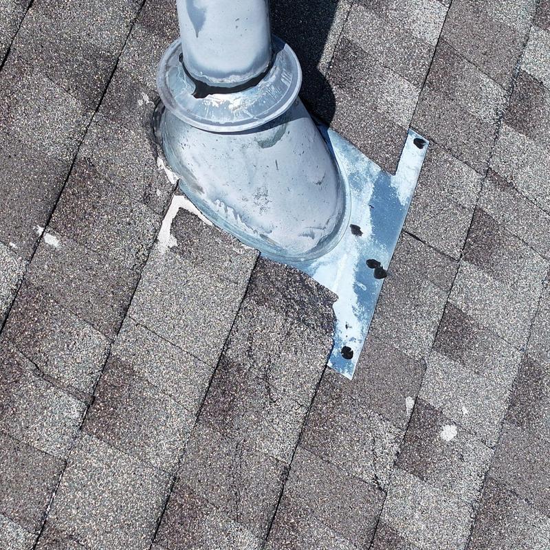 Roof vent pipe flashing with damaged shingles and sealant