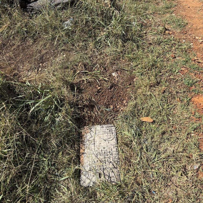 Water meter box buried in grass and dirt patch Water meter box buried in grass and dirt patch