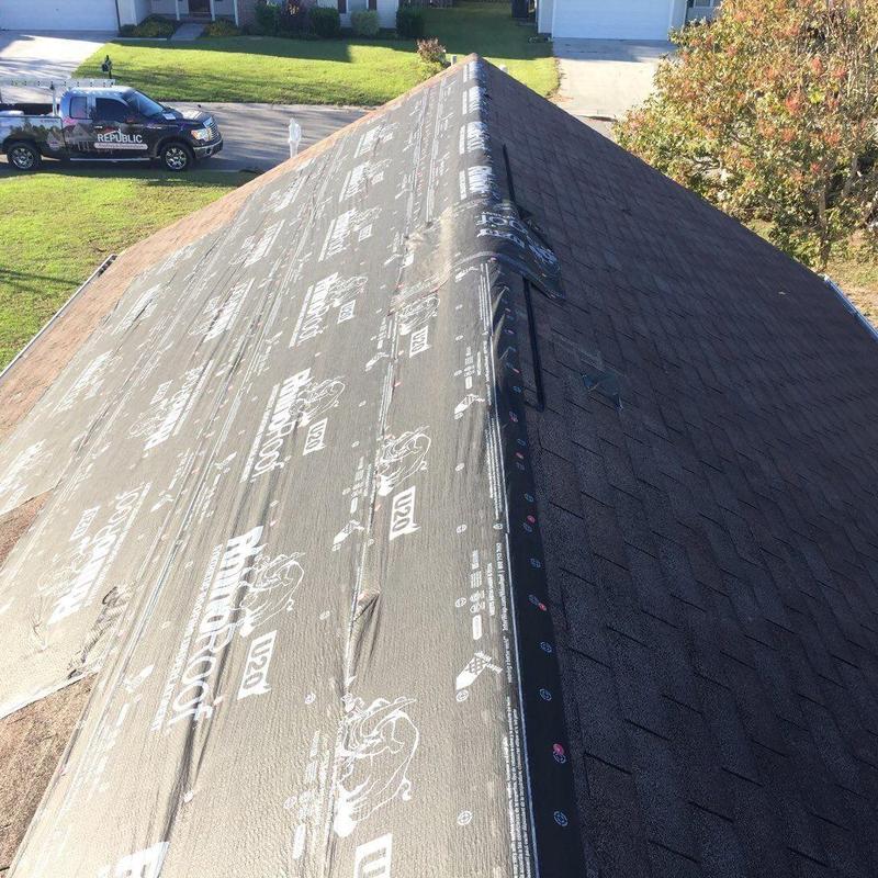 Roof underlayment and asphalt shingle installation in progress