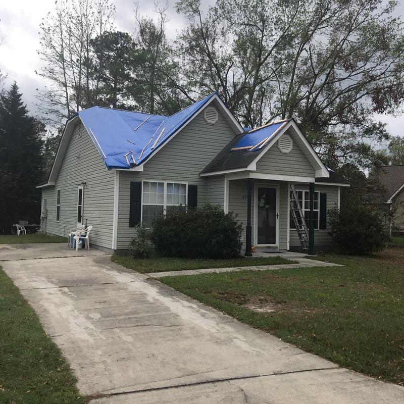 Roof tarps covering damaged shingles during hail inspection