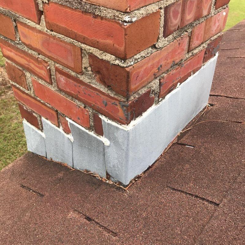 Chimney metal flashing and brick mortar on shingle roof