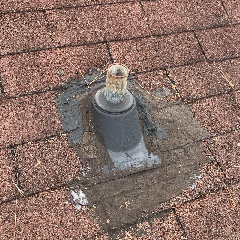 Roof pipe flashing with damaged sealant on shingle roof