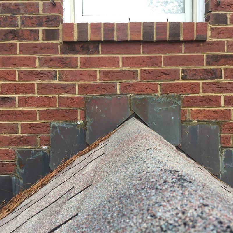Roof flashing on shingled roof and brick wall