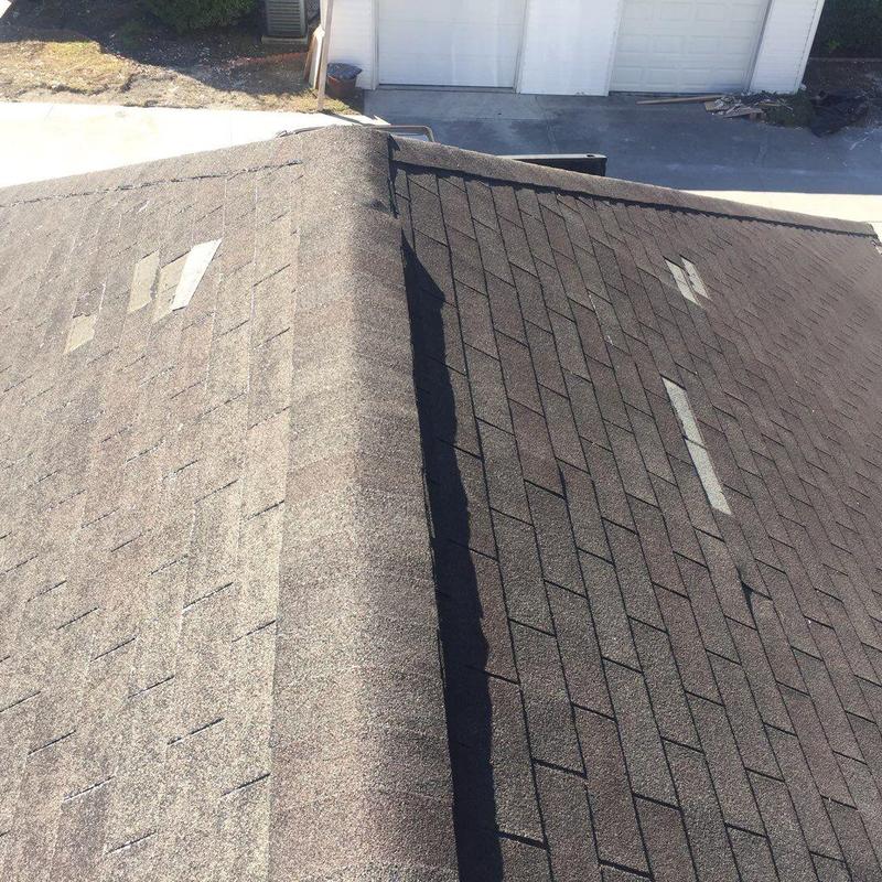 Asphalt roof shingles with visible hail damage patches