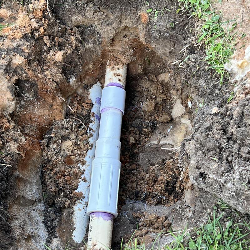 PVC sewer pipe joint with coupling in soil trench PVC sewer pipe joint with coupling in soil trench