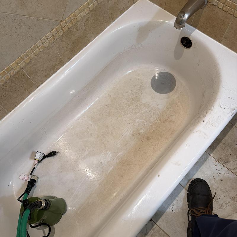 Bathtub with drain cleaning pump and hose setup Bathtub with drain cleaning pump and hose setup