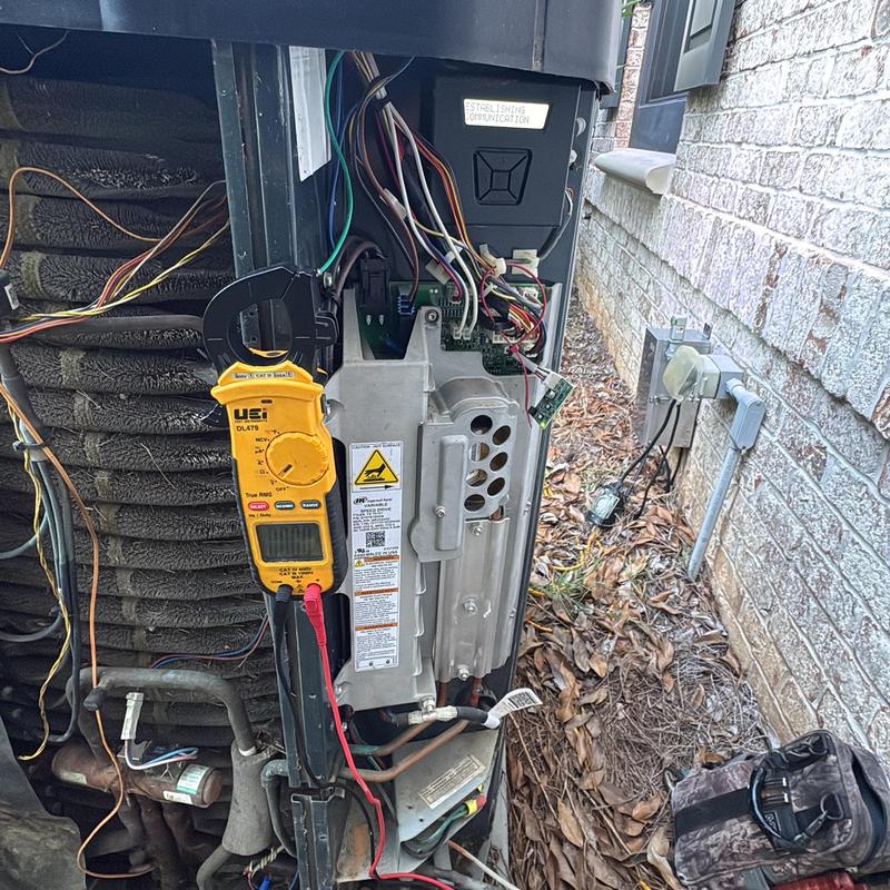 Heat pump control board with digital multimeter testing