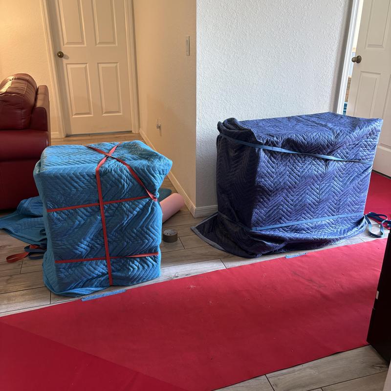 Furniture wrapped with moving blankets and secured