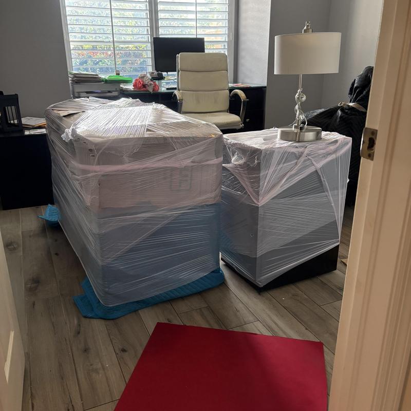 Office furniture wrapped for moving in plastic wrap