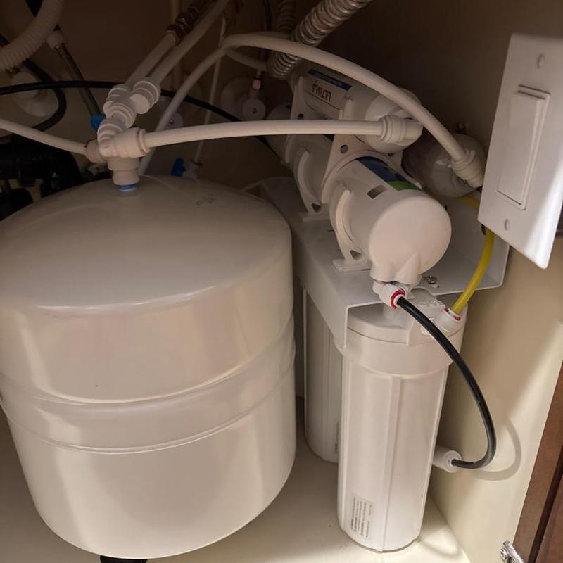 RO system filters and storage tank under sink