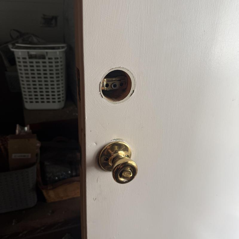 Door lock hole with brass doorknob during rekey job