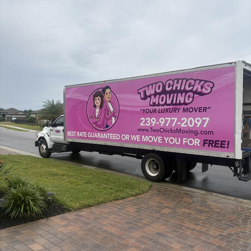 Moving truck parked on residential street near driveway