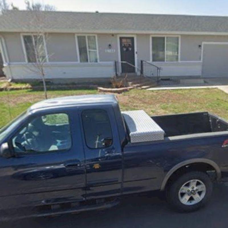 Pickup truck with diamond plate toolbox parked outside house