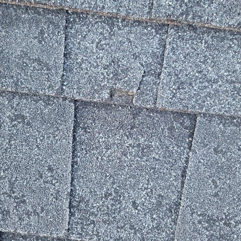 Asphalt shingle roof with weather-related cracking