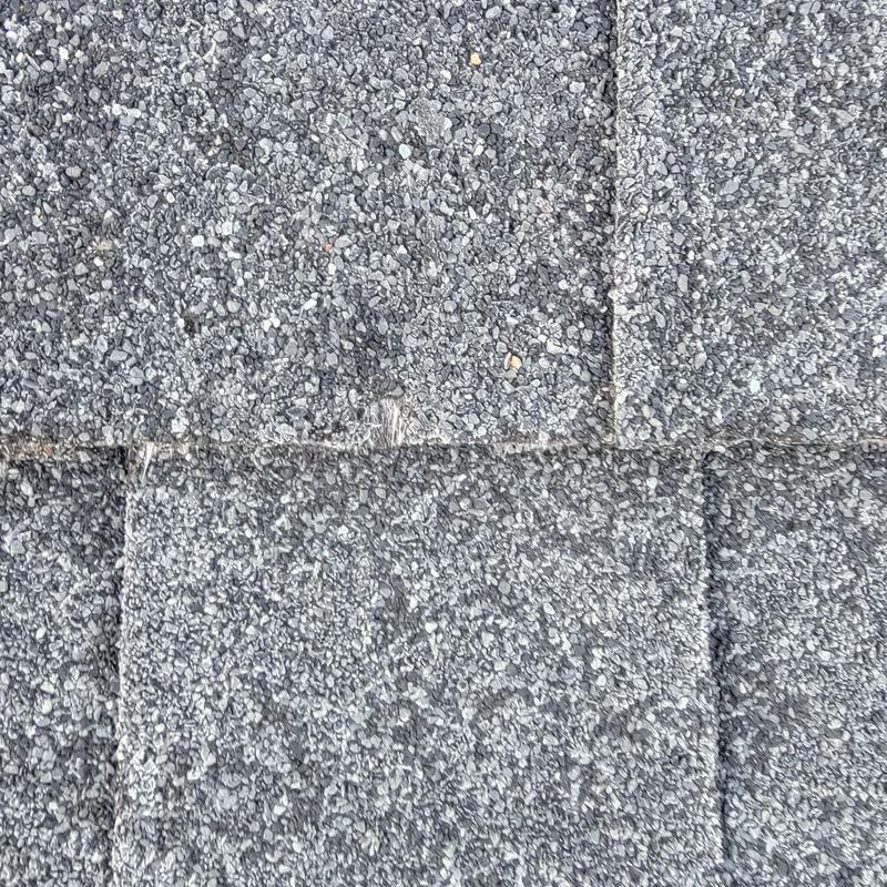 Asphalt shingles close-up showing cracking and wear
