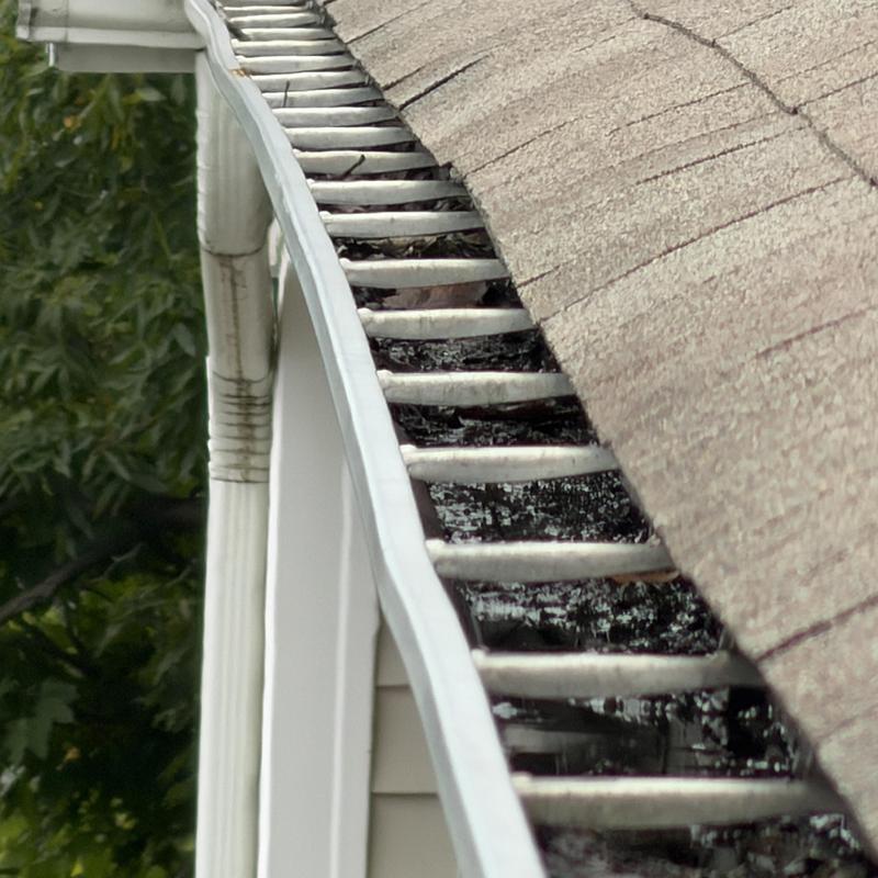 Gutter clog filled with leaves and shingle granules Gutter clog filled with leaves and shingle granules